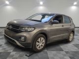 un SUV Volkswagen gris garé dans une pièce au sol carrelé