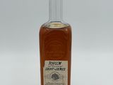 a close up of a bottle of rum on a white surface