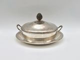 an antique silver plate with a lid and a bowl on it