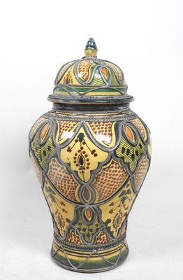 un vase jaune et vert muni d'un couvercle, sur fond blanc