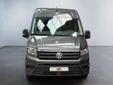 the front view of a grey vw transport van parked in a showroom