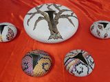 a group of painted rocks sitting on a red cloth