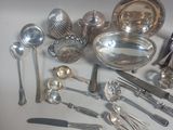 a lot of silver spoons and other silverware on the table