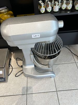 un mixeur posé par terre devant une étagère remplie de bocaux