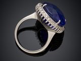 a close up of a ring with a blue stone and diamonds