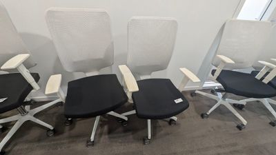 quatre chaises de bureau alignées dans une pièce vide