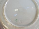 une assiette blanche avec une inscription verte, posée sur une table