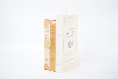 un livre posé à côté d'une boîte sur une surface blanche