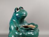 tirelire en céramique verte en forme de grenouille, avec une pièce d'or dans la bouche