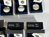 six silver coins are in a blue box on a white surface