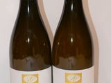 deux bouteilles de vin posées sur une table l'une à côté de l'autre
