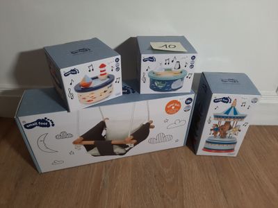 trois boîtes de jouets sont empilées les unes sur les autres par terre