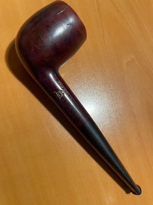 une pipe posée sur une table à côté d'une tasse de café