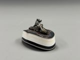 un gros plan sur une figurine représentant un chien assis sur un livre