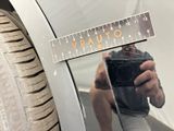 a man taking a picture of himself in the mirror of a car