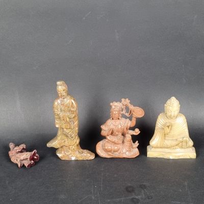 three small figurines of buddhas sitting on a black surface