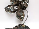 a metal flower that is sitting on a white surface