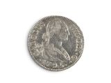 an old silver coin on a white surface with a white background