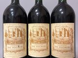 trois bouteilles de vin rouge sont alignées sur une table