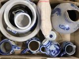 une boîte remplie de vases et de théières bleus et blancs