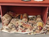 a red table with a bunch of pillows on it