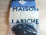 Deux paires de chemises pour homme sont emballées dans du plastique sur une table.