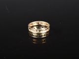 une bague en or avec des diamants sur une surface noire