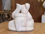 une sculpture en marbre représentant un homme et une femme assis sur un banc