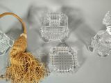 four glass objects on a white surface with a tassel