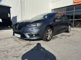 La voiture grise est garée devant un immeuble, sur un parking.