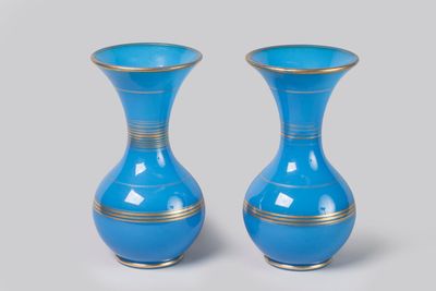 une paire de vases bleus aux bords dorés sur fond gris