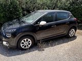 a picture of a black car parked on a gravel road