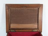 a small wooden box with a red cloth inside of it