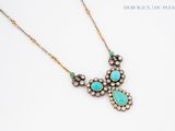 a necklace with turquoise stones and pearls on a white surface