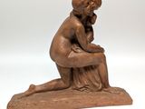 statue of a woman sitting on a rock with her hand on her chin
