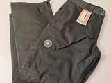 Le pantalon est noir et porte une étiquette