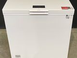an image of a white chest freezer sitting on top of a cement floor