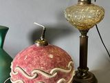 three vases and a lamp on a table next to each other