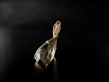 a close up of a gold pendant on a black surface