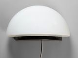 un gros plan d'une lampe murale avec un abat-jour blanc