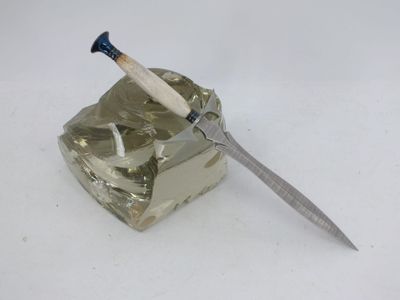un couteau posé sur un cendrier en verre