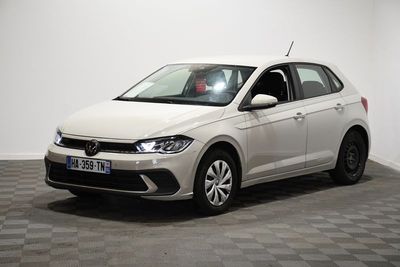 la volkswagen polo blanche est garée dans une pièce au sol en damier
