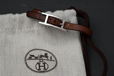 un sac blanc muni d'une bandoulière marron et d'une boucle argentée