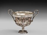 une coupe ancienne en argent, munie d'anses et de poignées, posée sur un socle