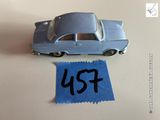 une petite voiture posée à côté d'une feuille de papier