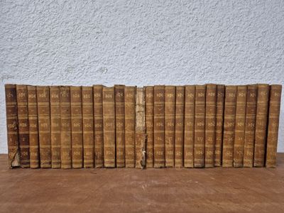 a stack of old books sitting on top of a wooden table