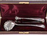 a silver spoon and spoon set in a red box