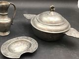 a silver teapot and a silver plate on a table