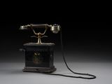 an old fashioned telephone sitting on top of a wooden stand