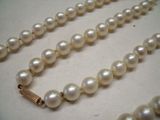collier de perles avec un fermoir en or et une perle blanche